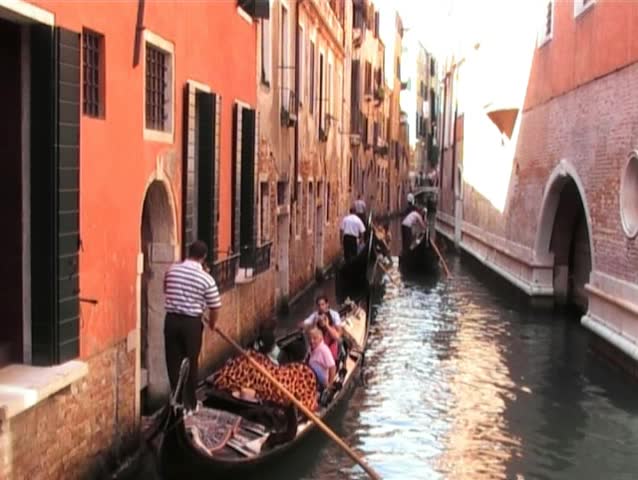 gondolas passing along narrow canal viewed from bridge