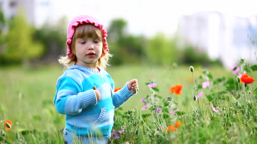 Child in a field of laughs, hiding in the grass