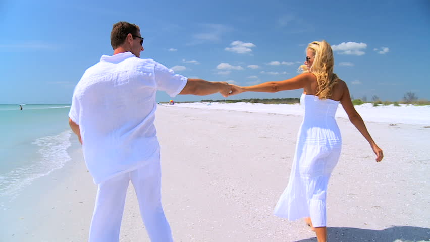 Attractive blonde caucasian couple in love having fun spending time together on the beach 60FPS 