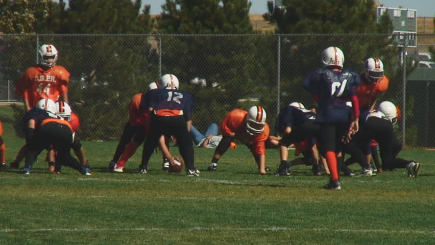 Youth football teams enjoy full contact game-passing play; HD, audio 