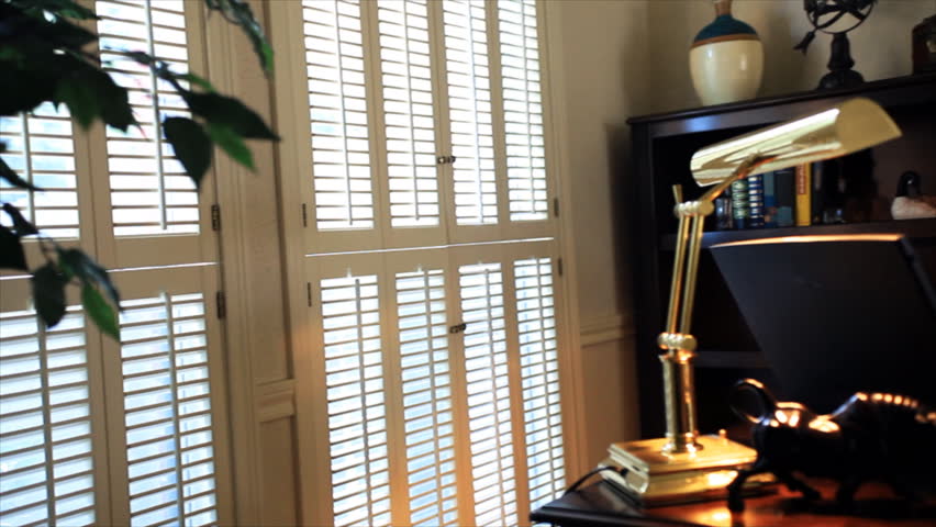 A daydreaming businessman sitting in his home office or study, gazing at the sunlight windows.