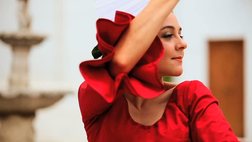 Beautiful lady dancing traditional spanish flamenco in town square Seville in close-up