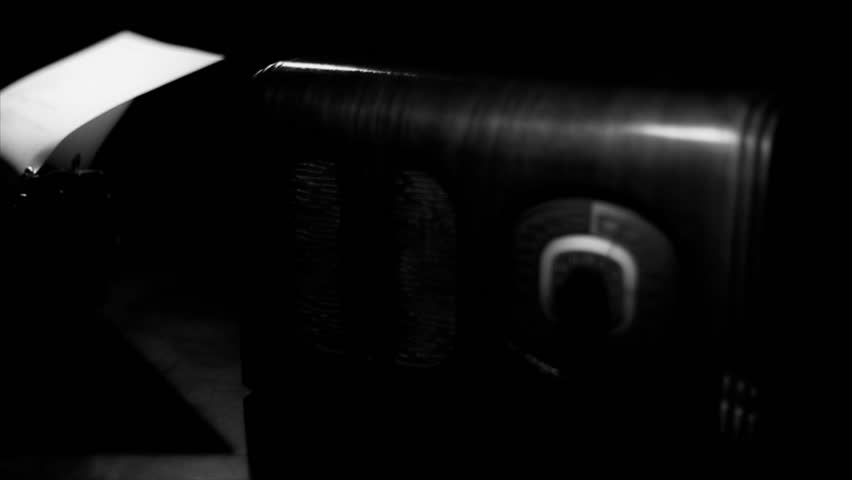 The camera moves past a vintage radio to reveal a man typing away on a 40's period manual typewriter. Film Noir, Dolly Shot