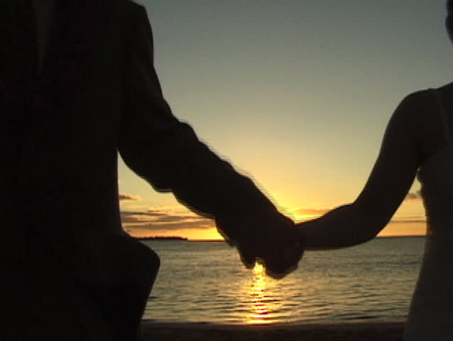 Hands over Hanalei Bay Kauai sunset