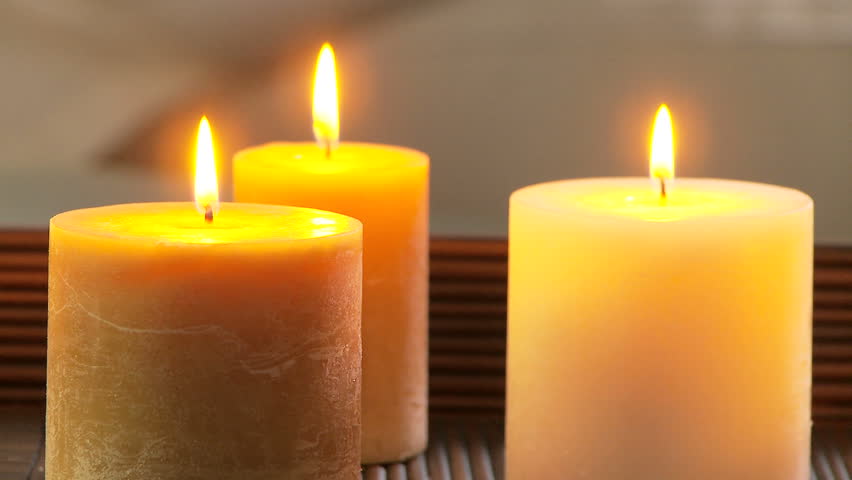 Portrait of woman on sofa meditating with candles