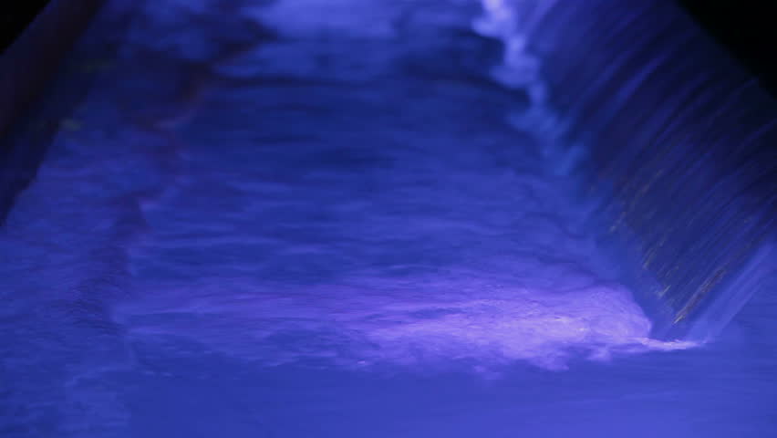 Water blue. A small waterfall and a torrent of water. Blue light water.