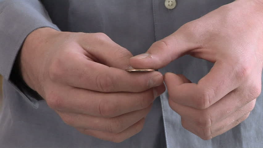 Close up of male tossing a coin