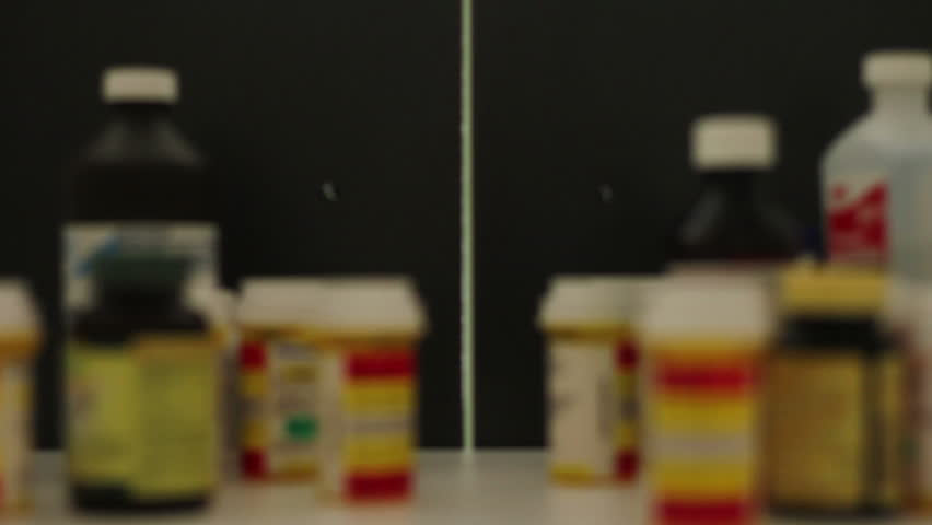 Older man choosing pills from medicine cabinet
