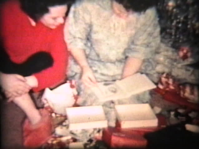 A family enjoys opening up Christmas presents together including the mother getting some new China.