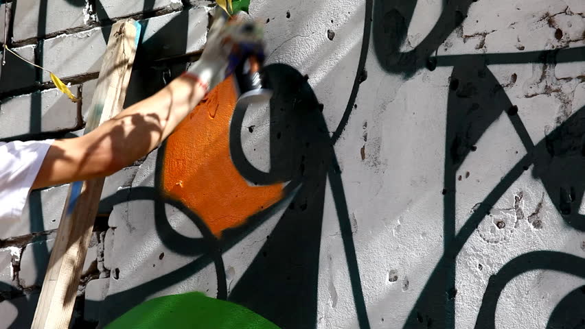 Painting a wall with orange spray paint