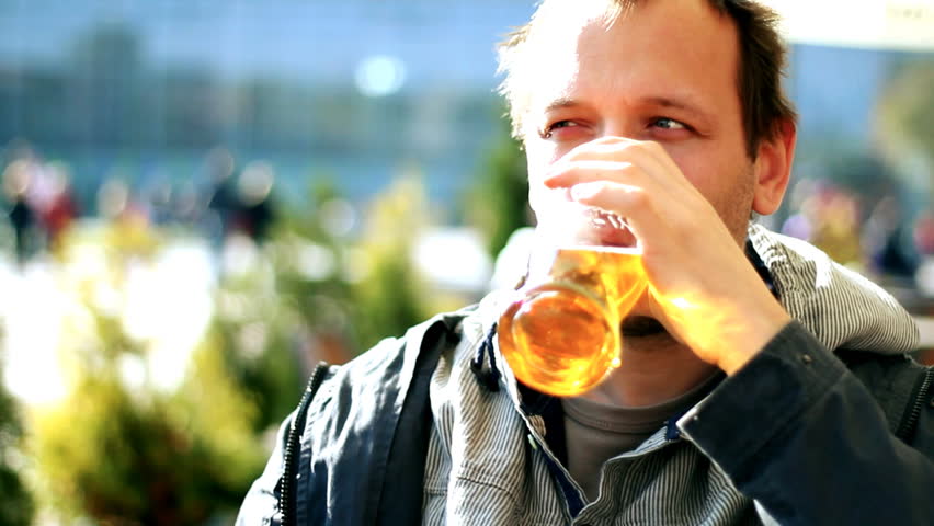 Man drinking beer outdoors,  steady cam shot 