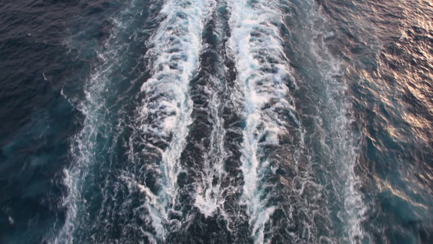trace of cruise liner on water surface of evening sea in sunset light, top view