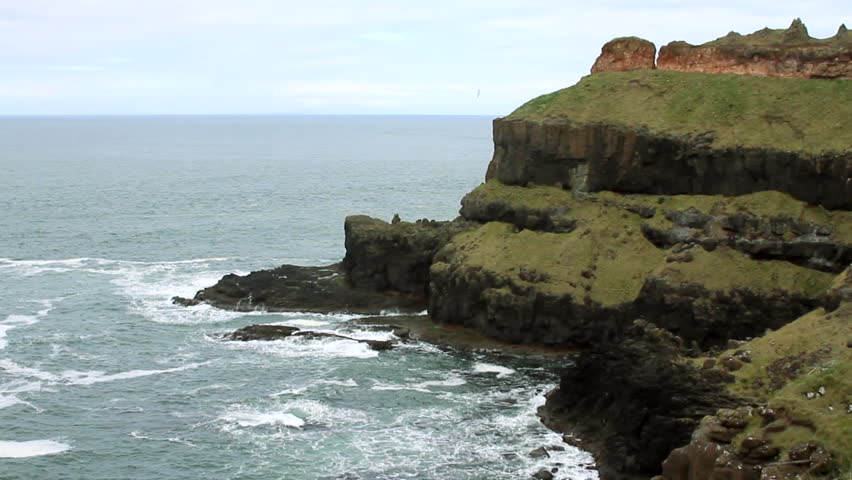 Waves crash into Northern Ireland cliffs along the sea