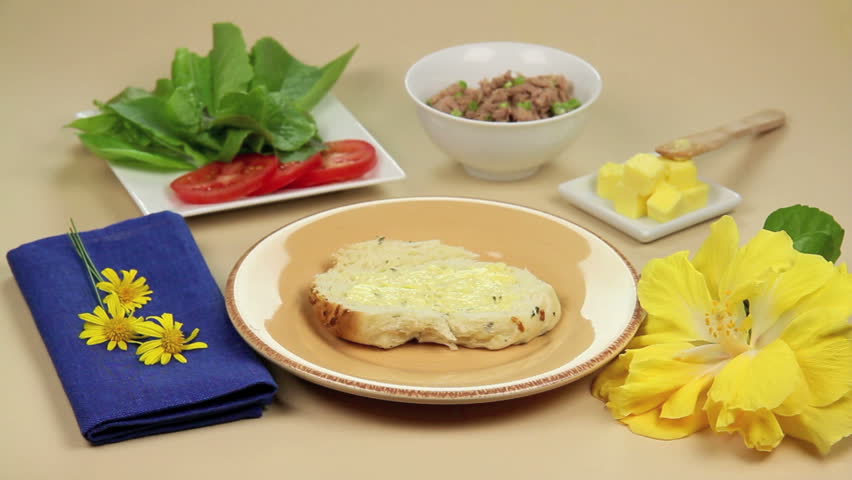 Edited sequence of preparing a tuna and salad roll or sandwich ready to serve.