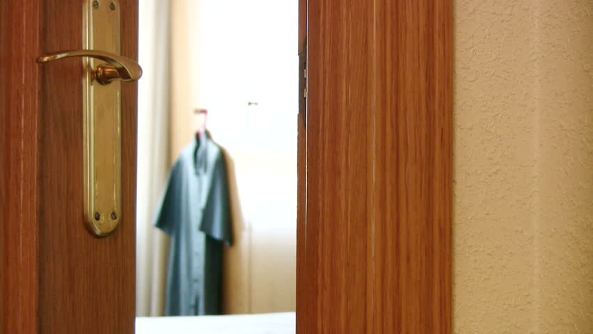 Man hangs "Do Not Disturb" sign on a hotel room door