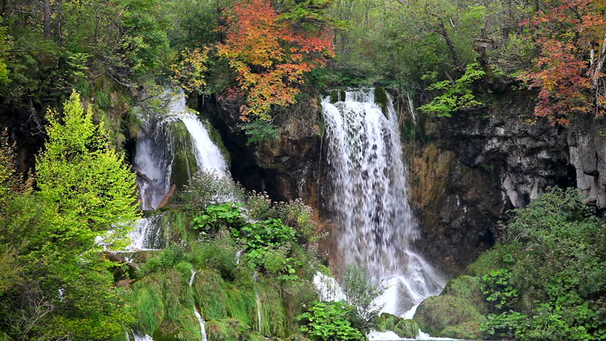 Tranquil waterfall scenery in the middle of autumn forest