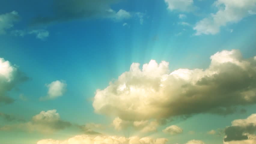 Time lapse clip of white fluffy clouds over blue sky 