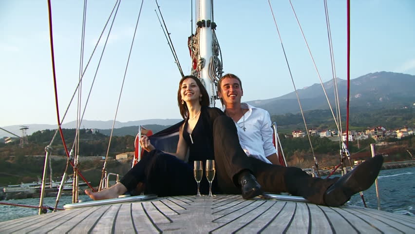 Two lovers ride on the deck of a yacht