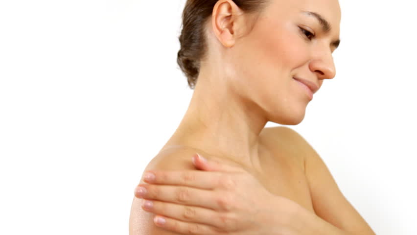 Young woman applying moisturizer to her skin 