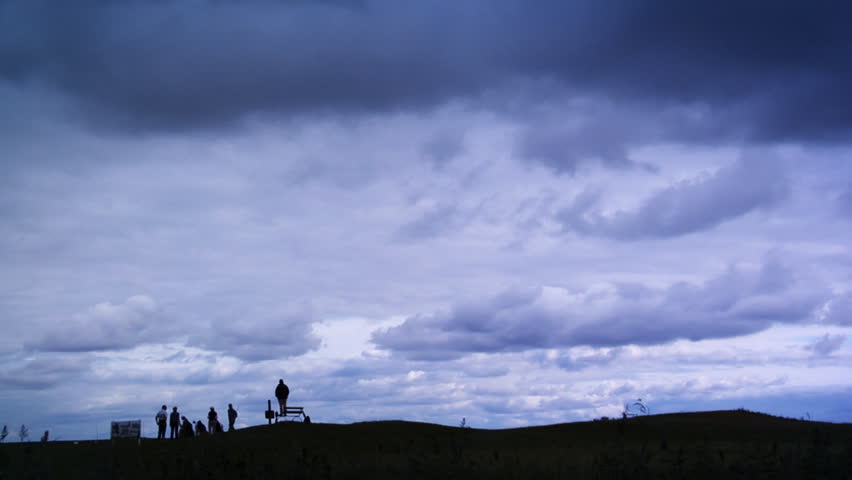 Cloudscape scenery over a golf course with golfers in the foreground