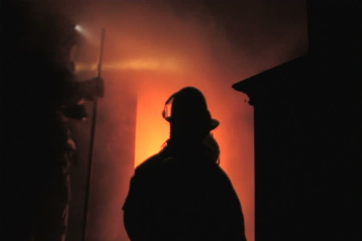 Firefighters examine fire during a training burn