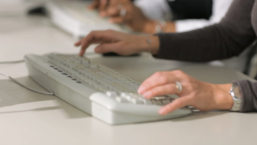 multiethnic group of female customer service representatives talking on the phone and typing on computer keyboard