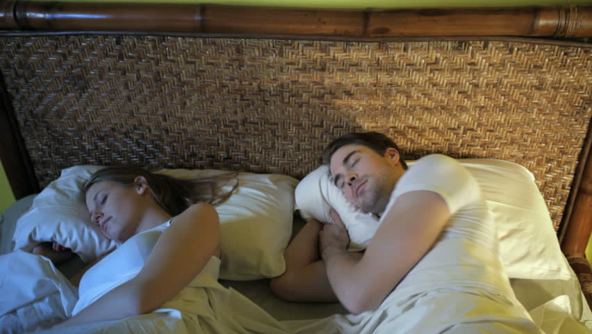 caucasian heterosexual couple in bed, man suffering from insomnia. Crane shot