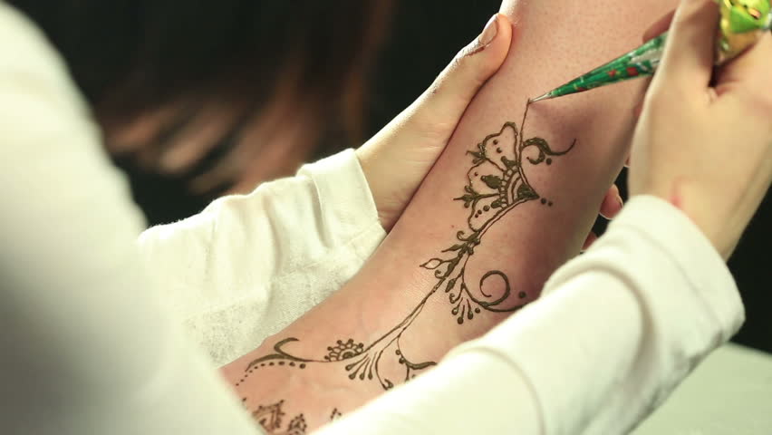 an indian lady does a henna tattoo on a client u0027s hand and wrist an indian lady does a henna tattoo on a client u0027s hand and wrist