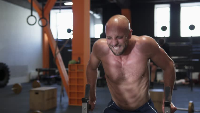 Heated Sweaty Fitness Man Doing Bar Dips Workout In Gym