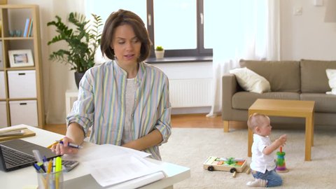 multi-tasking, freelance and motherhood concept - working mother with baby boy at home office