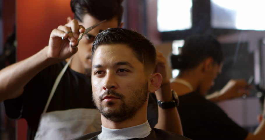 4k00 15front View Of Attentive Mixed Race Barber Trimming Clients