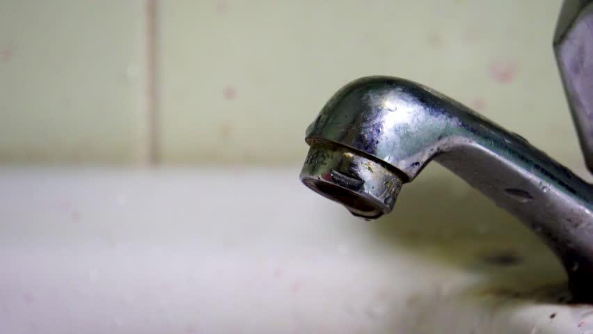 Metal Dirty Retro Faucet Slowly Dripping Water In White Sink In