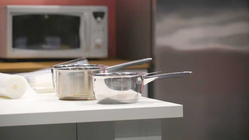 4k00 09two Cooking Pans On The Corner Of Table With Two Cooking Pans On The Corner Of Table With Microwave Oven Back