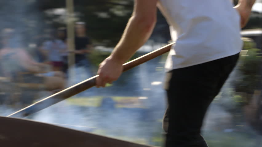 Hd00 11a Pit Master Adds Wood To A Fire Cooking A Pig At A