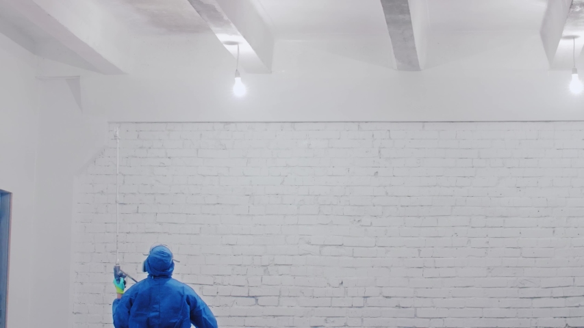 Worker Painting The Ceiling By Airless Spray Gun With White Color