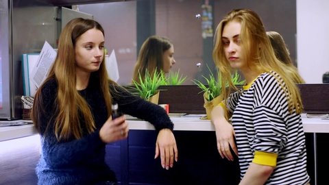 Vape lgbt teenagers. bisexual lesbian young caucasian teenage girls smoking  an electronic cigarette in vape bar. bad habit that is harmful to health.  young pretty white caucasian teens vaping indoors.
