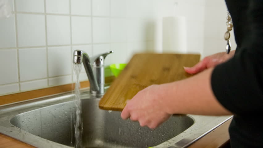 Kitchen Sink With Clean Dishes wash out plate under water. person cleaning dirty dishes in Kitchen Sink With Clean Dishes wash out plate under water. person cleaning dirty dishes in