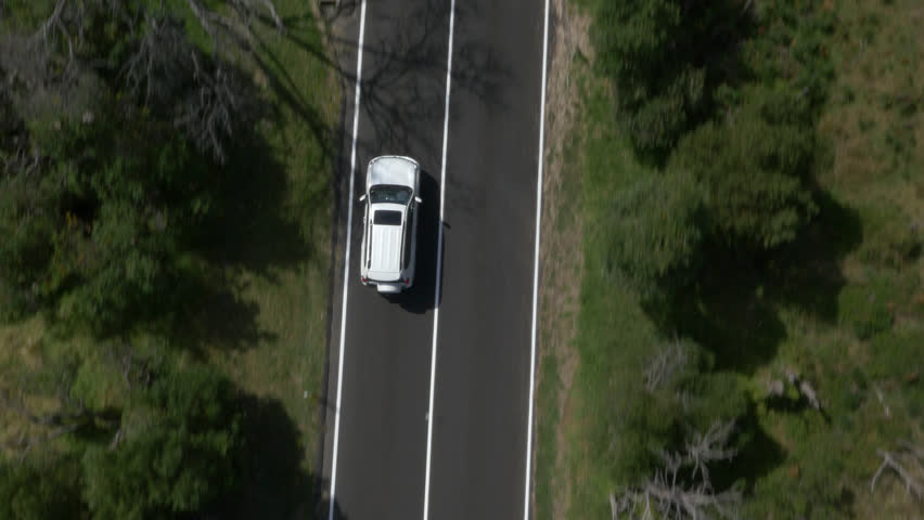 Aerial Drone Shot Of Car Diving Along Road In A Forest Stock Footage ...