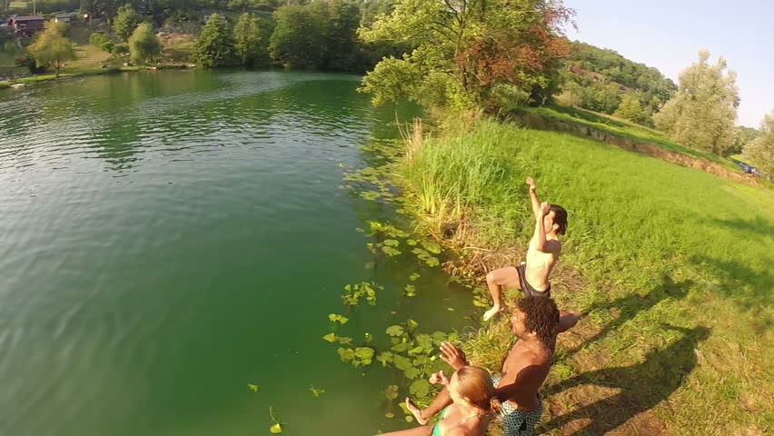 Young Blonde Girl Jumping Off Rope Swing Into River At Sunset Stock ...