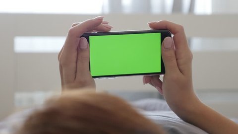 Woman In Hands Holds Green Screen Display Smart Phone 4k 2160p 30fps Ultrahd Footage Female In Bedroom Resting With Greenscreen Device 3840x2160 Uhd Video