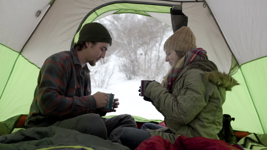 Couple Warm Up (On Winter Camping Trip) With Steaming Hot Cocoa,They Cheers And Carefully Sip