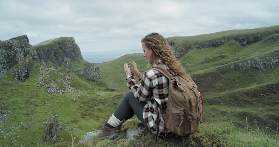 Independent Woman Traveller Sitting At Edge Of Cliff Looking Out Independent Woman Traveller Sitting At Edge Of Cliff Looking Out