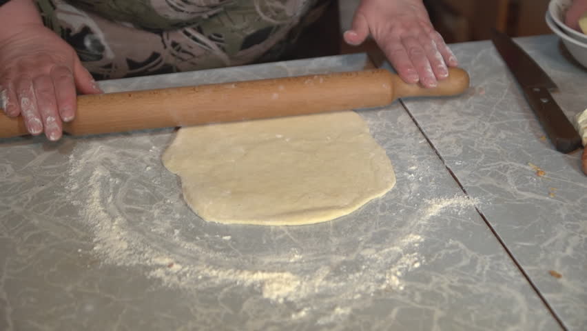Kitchen Table Close Up a brunette woman makes a pizza dough on a light kitchen table at Kitchen Table Close Up a brunette woman makes a pizza dough on a light kitchen table at