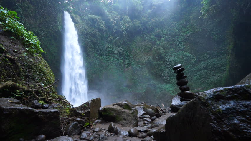 Amazing Nungnung Waterfall Falling Water Stock Footage 100 Amazing Nungnung Waterfall Falling Water Hitting Surface Some Huge Rocks Seeable In Front Of Frame Lush Green Leafes Is Moving From The Wind Bali