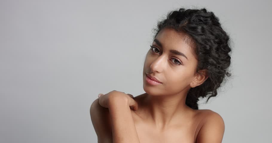Cute Young Middle Eastern Model With Nude Shoulders And Lightly Braided Wavy Black Hair And
