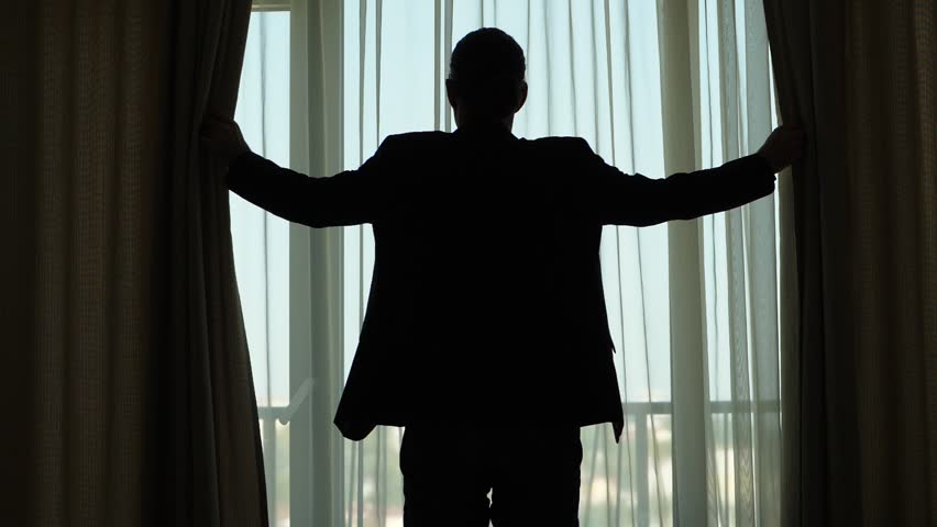 Hd00 33guy Standing Against Window Holding Curtains By Hands