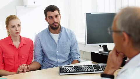 family planning, medicine and healthcare concept - couple visiting doctor at fertility clinic