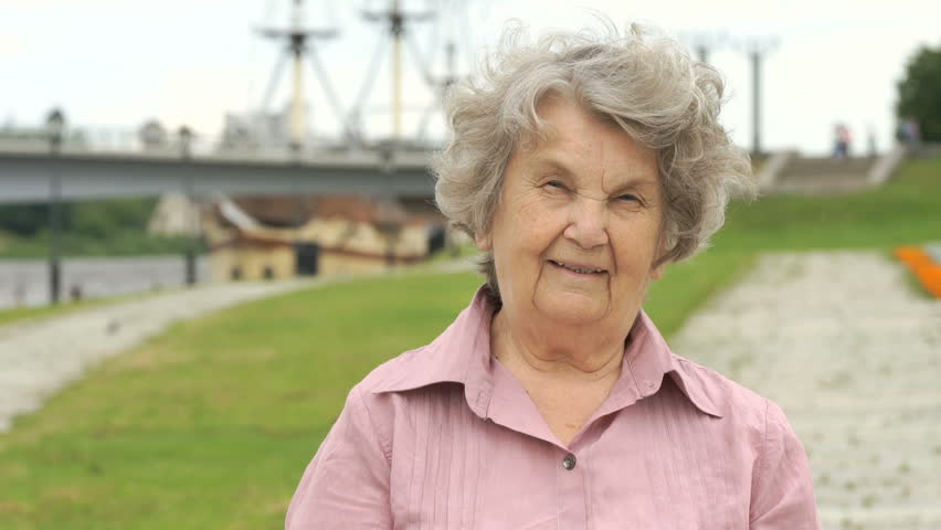 Portrait Of Smiling Mature Old Woman With Gray Hair Aged 80s Outdoors