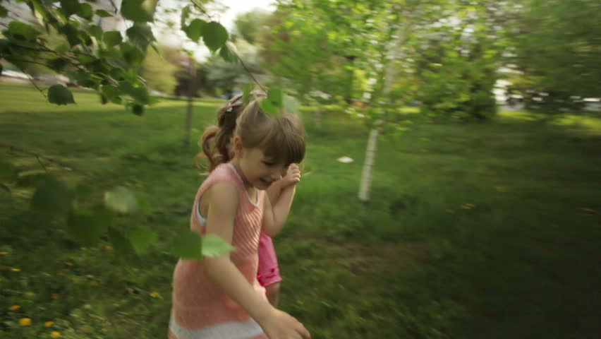 Cute girls running in garden and smiling
