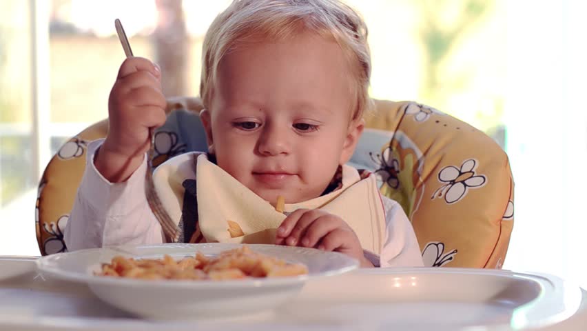 Two Year Old Child Girl Eats With Fingers In Front Of The Computer With ...